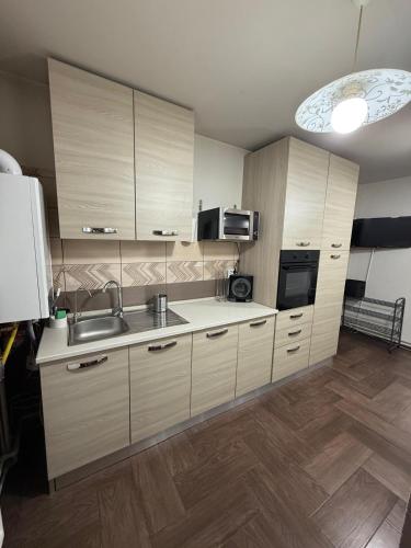 a kitchen with wooden cabinets and a sink at Apartament Craiova in Craiova