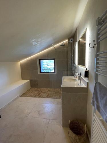 a bathroom with a sink and a tub and a television at Domaine de La Font des Pères - Teritoria in Le Beausset