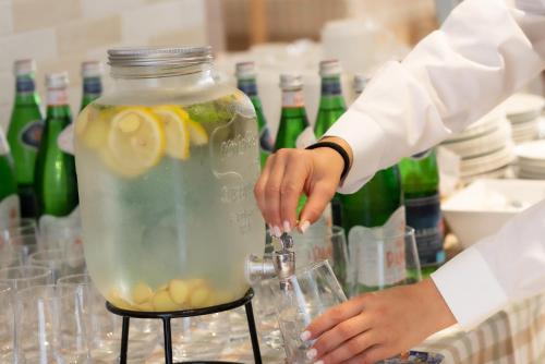a person is making a drink in a vase at Hotel Jesulum in Lido di Jesolo