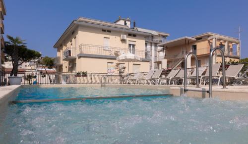 a swimming pool in front of a house at Hotel Jesulum in Lido di Jesolo