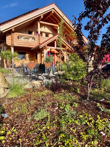 a log house with a garden in front of it at "Allgäu-Herzl" Alpenchalet für Zwei in Rückholz