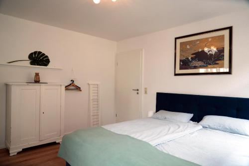 a bedroom with two beds and a picture on the wall at Eifel Fewo in Neuerburg