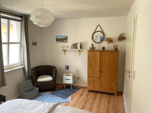 a bedroom with a bed and a chair and a mirror at Eifel Fewo in Neuerburg