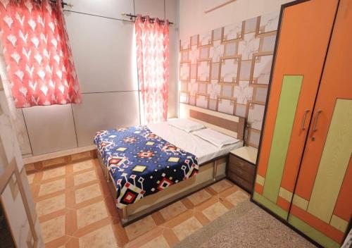 a small bedroom with a bed and a window at Kalindi Blessings Deluxe Guest House in Mathura