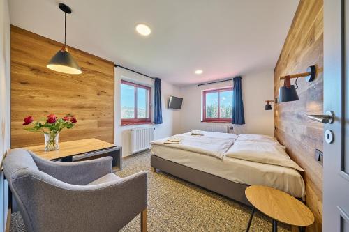 a bedroom with a bed and a table and chairs at Hotel Bouda Jana in Pec pod Sněžkou