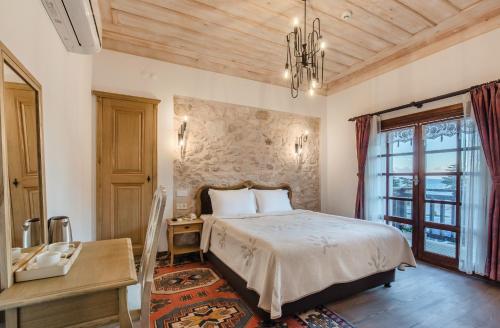 ein Schlafzimmer mit einem Bett mit einer Steinmauer in der Unterkunft Eskiciler Konağı in Egirdir
