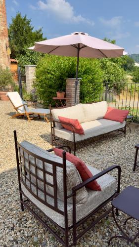 a patio with two chairs and an umbrella at La Corte Nascosta Volpedo in Volpedo