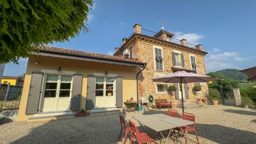 a table with an umbrella in front of a building at La Corte Nascosta Volpedo in Volpedo