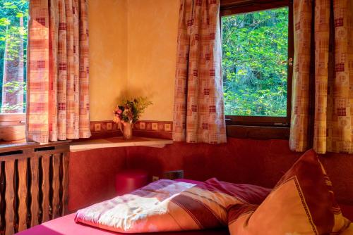 a bedroom with a bed and a window with curtains at Hotel Schmausemühle in Gondershausen