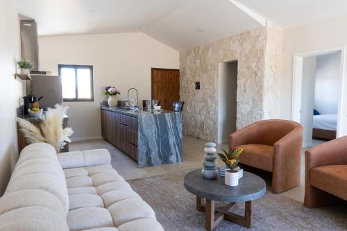 a living room with a couch and a table at Villas Baja Toscana de Rancho Olivares in Ensenada