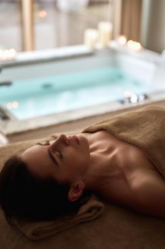 a woman laying on a towel on the floor at Palanga Life Balance SPA Hotel in Palanga