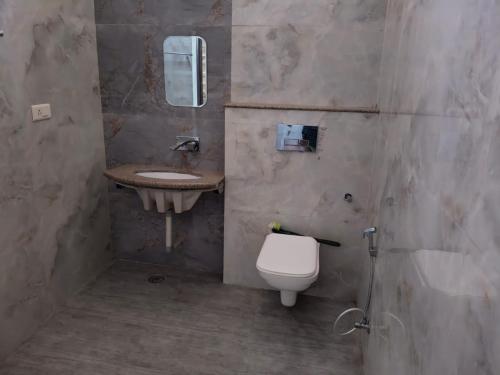 a bathroom with a toilet and a sink at Kalindi Blessings Deluxe Guest House in Mathura