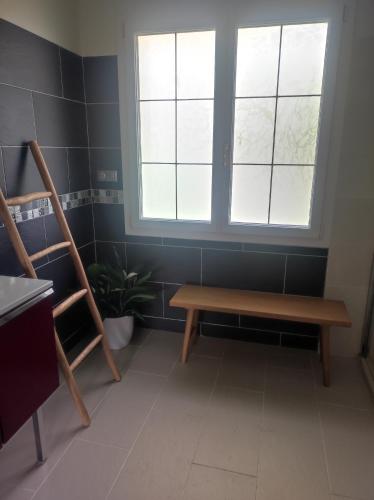 a room with a wooden bench and a window at Le jardin d'Annie in Jaucourt