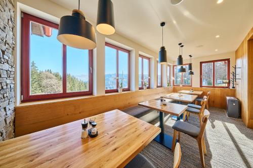 a row of tables in a restaurant with windows at Hotel Bouda Jana in Pec pod Sněžkou