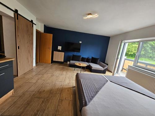 Un dormitorio con una cama y una sala de estar. en Grmač Apartments, en Naklo