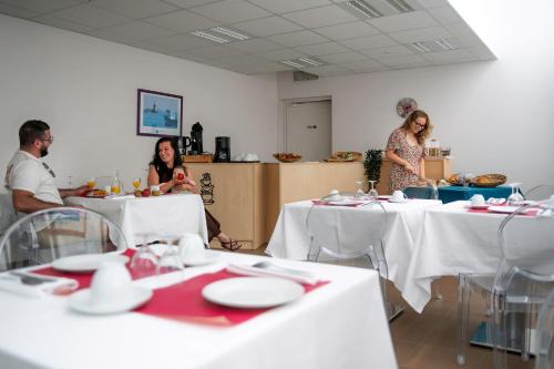 eine Gruppe von Menschen, die in einem Raum an Tischen sitzen in der Unterkunft Goélia Les 7 Iles in Perros-Guirec