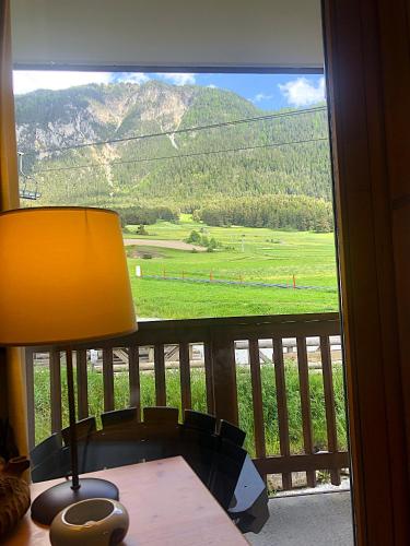 a lamp sitting on a table in front of a window at Balcons B 011 - PARC NAT VANOISE appart 6 pers in Val Cenis