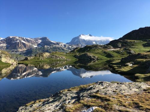 a mountain reflecting in a lake in the mountains at Balcons B 011 - PARC NAT VANOISE appart 6 pers in Val Cenis