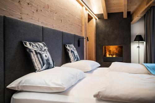 two beds with white pillows in a bedroom at Hotel Antines in La Villa