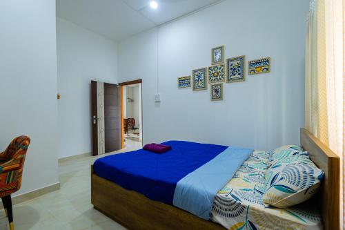 a bedroom with a bed with a blue comforter at Hostello Backpackers in Dibrugarh