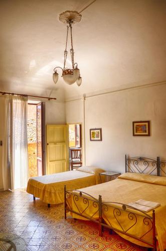サント・ステーファノ・ディ・カマストラにあるB&B Le Coccinelleのベッドルーム1室(ベッド2台、シャンデリア付)