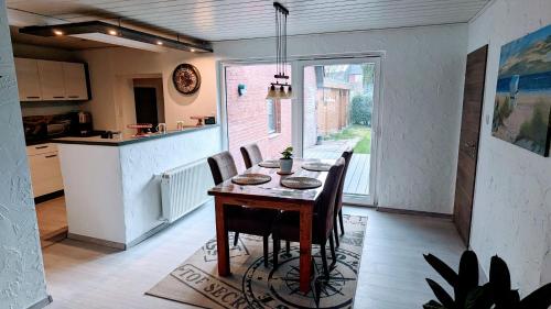 Una cocina y un comedor con mesa y sillas. en Ferienhaus Meer & Mehr, en Wilhelmshaven