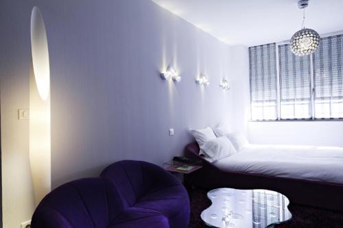 a room with a purple chair and a bed at Demeures & Châteaux La Belle Meuniere in Royat