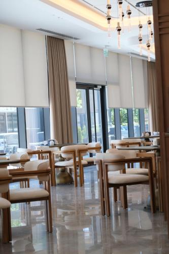 a restaurant with wooden tables and chairs and windows at Sia Hotel Thermal & Spa in Nilüfer