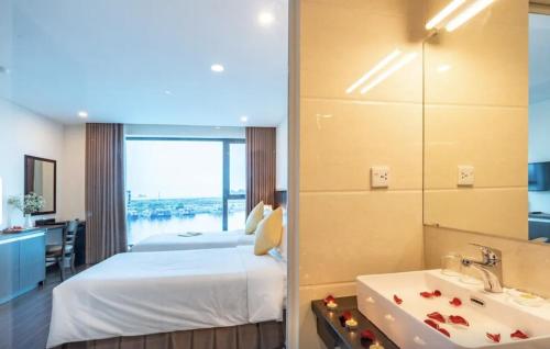 a bedroom with a bed and a sink and a tub at Pearl Hotel Tuan Chau - Ha Long in Ha Long