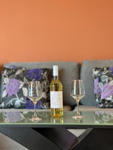 a bottle of wine and two wine glasses on a table at Roe Sea View in Kyparissia