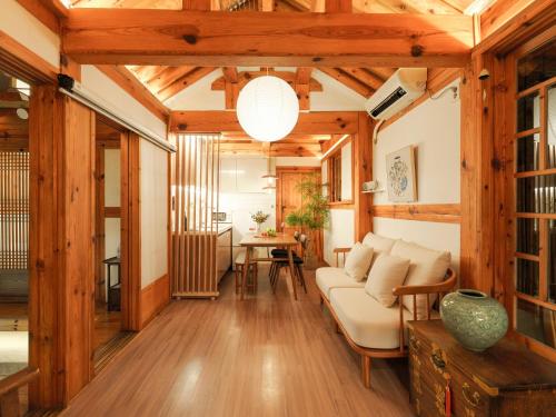 a living room with a couch and a table at #오픈할인# 경복궁역 도보 4분#한옥#전통체험#경복궁,인사동,북촌,서촌,광화문,명동, 동대문 바로 옆#짐보관# 9인#호텔침구#각방에어컨#무료와이파이#세탁건조기#교통최고 in Seoul