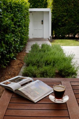a book and a cup of coffee on a wooden table at La Paris Estate in Franschhoek