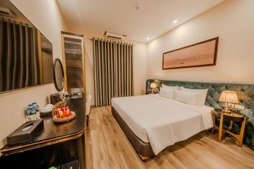 a hotel room with a large bed and a desk at San Hotel & Spa in Hanoi
