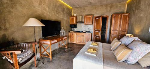 a living room with a couch and a desk and a table at Les Terrasses Suites in Calheta