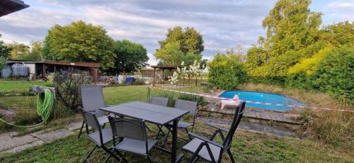 a table and chairs in a yard with a pool at Bungalow Helga in Fürstenwalde