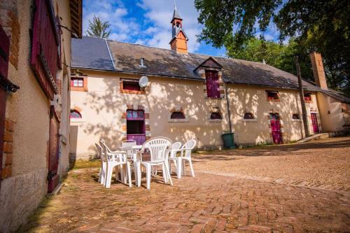 a group of tables and chairs in front of a building at La Forge in Cour-Cheverny