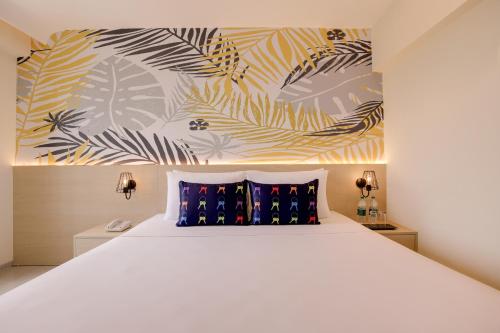 a bedroom with a large white bed with blue pillows at Keys Lite by Lemon Tree Hotels, Banswara in Bānswāra