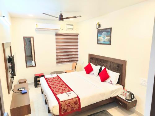 a bedroom with a large bed with red pillows at MG Park in Chennai