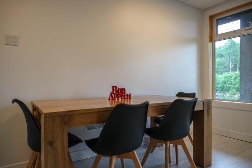 a dining room with a wooden table and chairs at Entre lac et Fleuve - Nature & Comfort in Saint-Siméon