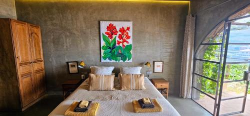 a bedroom with a bed and a painting on the wall at Les Terrasses Suites in Calheta