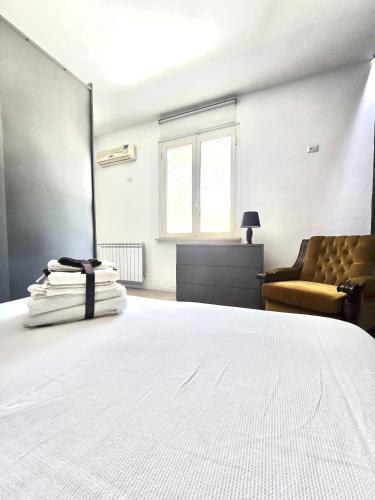 a bedroom with a large white bed and a chair at Tito Pomponio in Frosinone