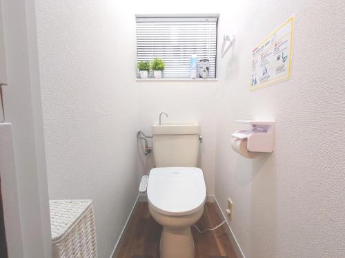 a small bathroom with a toilet and a window at 犬山城に近い大人数宿泊が可能で駐車場あり in Inuyama