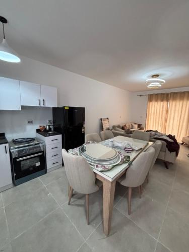 a kitchen and dining room with a table and chairs at شاليه فاخر in Dawwār Abū Maḩrūs