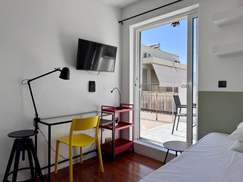 a bedroom with a table and chairs and a window at Athenian Sky in Athens