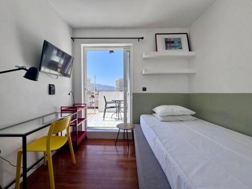 a bedroom with a bed and a desk and a balcony at Athenian Sky in Athens