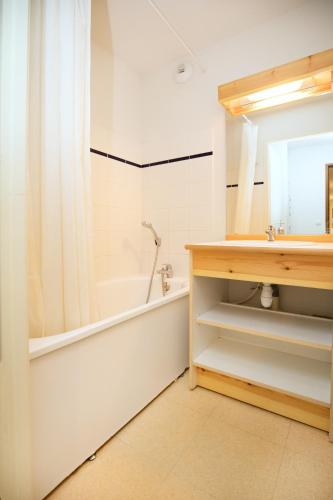 Val CenisにあるBalcons B 015 - PARC NAT VANOISE appart 6 persの浴槽、洗面台、鏡のあるバスルーム