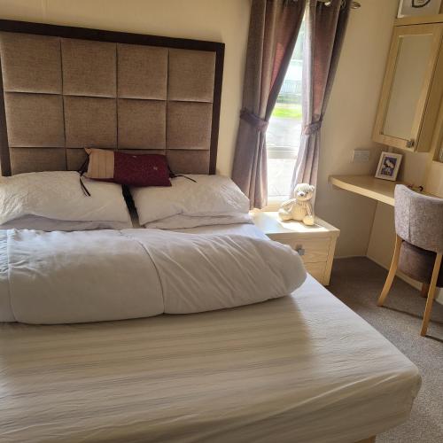 a bedroom with a large bed and a window at 125 Maple Lake Southview Caravan Park in Winthorpe