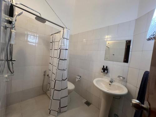 a bathroom with a sink and a toilet and a mirror at PearlDrop Hills Kandy in Kandy