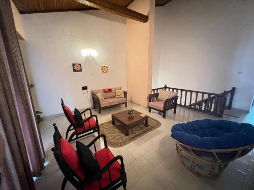 a living room with chairs and a couch and a table at PearlDrop Hills Kandy in Kandy