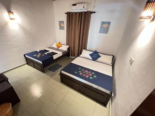 two beds in a small room at PearlDrop Hills Kandy in Kandy